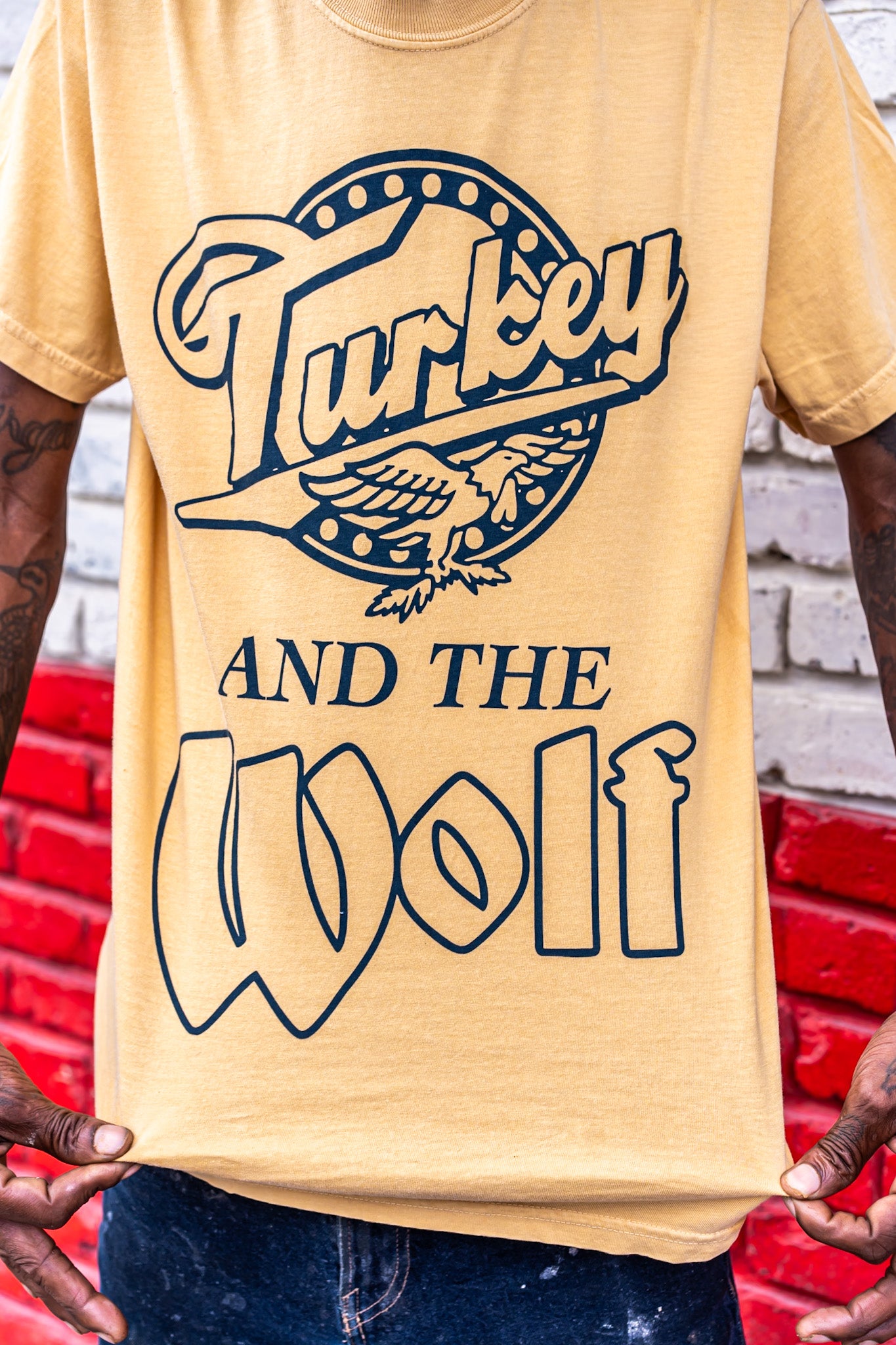Person wearing a yellow t-shirt with 'Turkey and the Wolf' design.