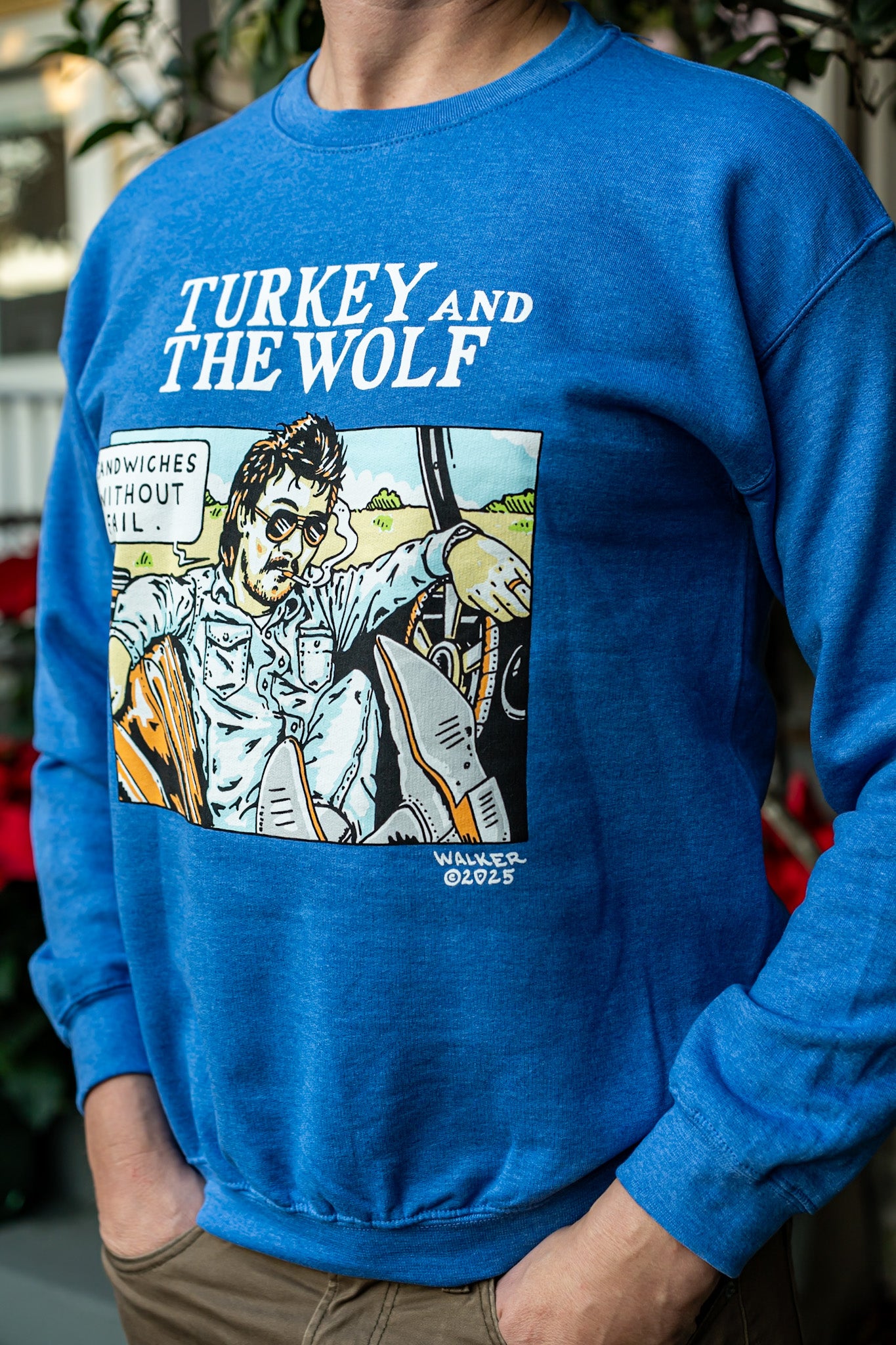 Person wearing a blue sweatshirt with a graphic design and text 'TURKEY AND THE WOLF'.