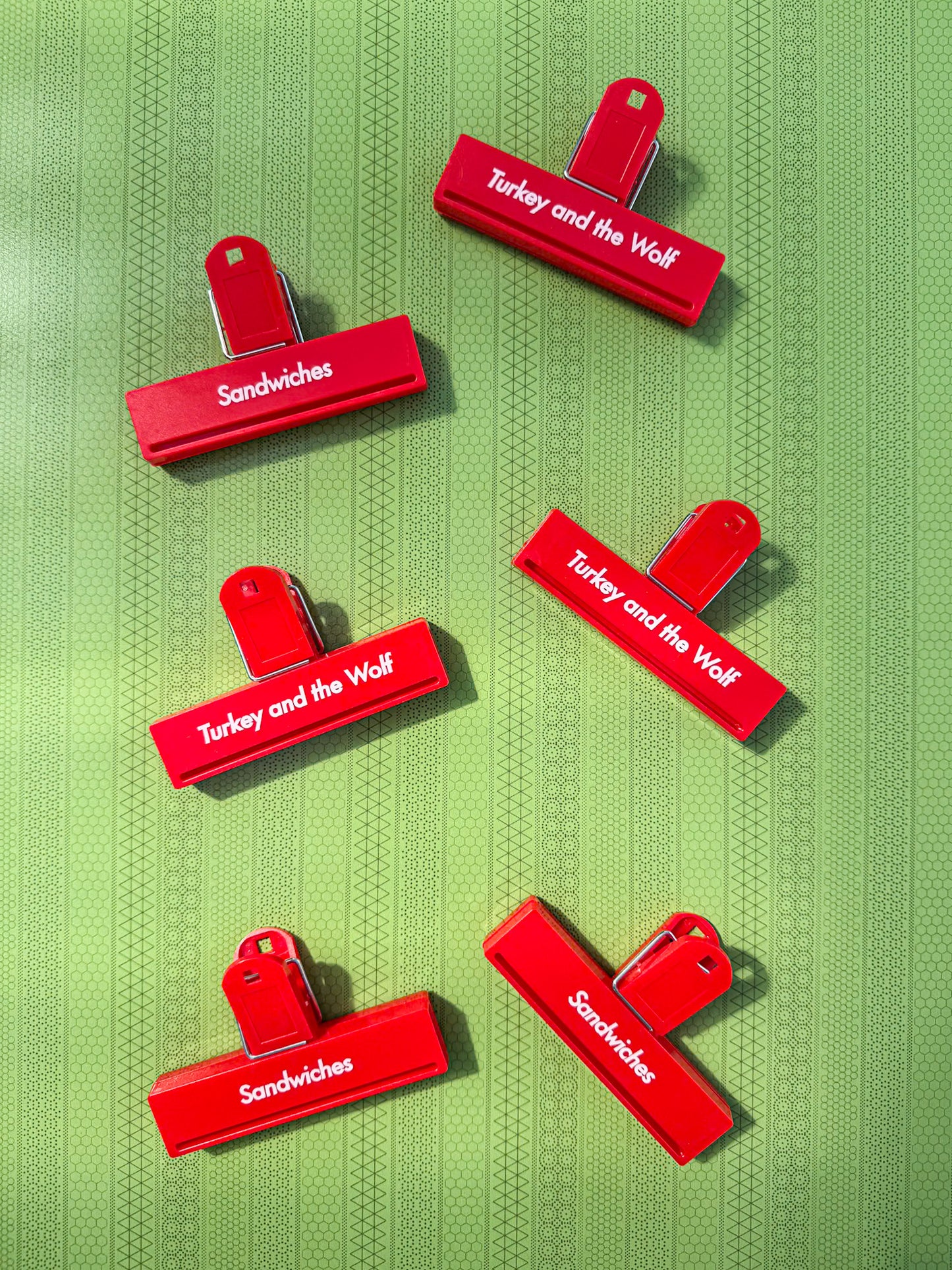 Red clips with text on a green textured background