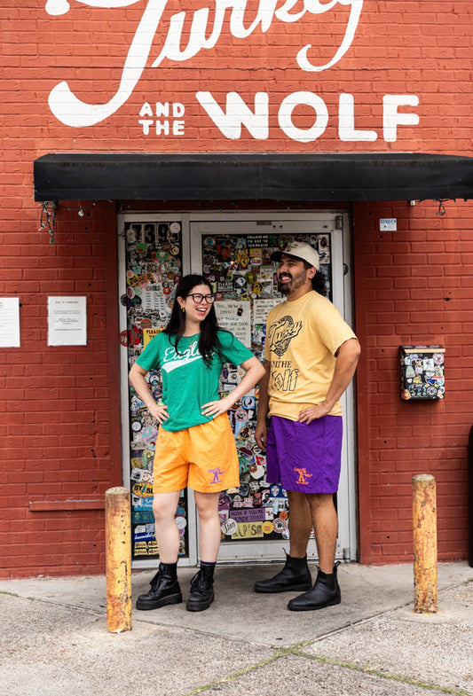 Two people standing in front of a building with 'Turkey and the Wolf' sign.