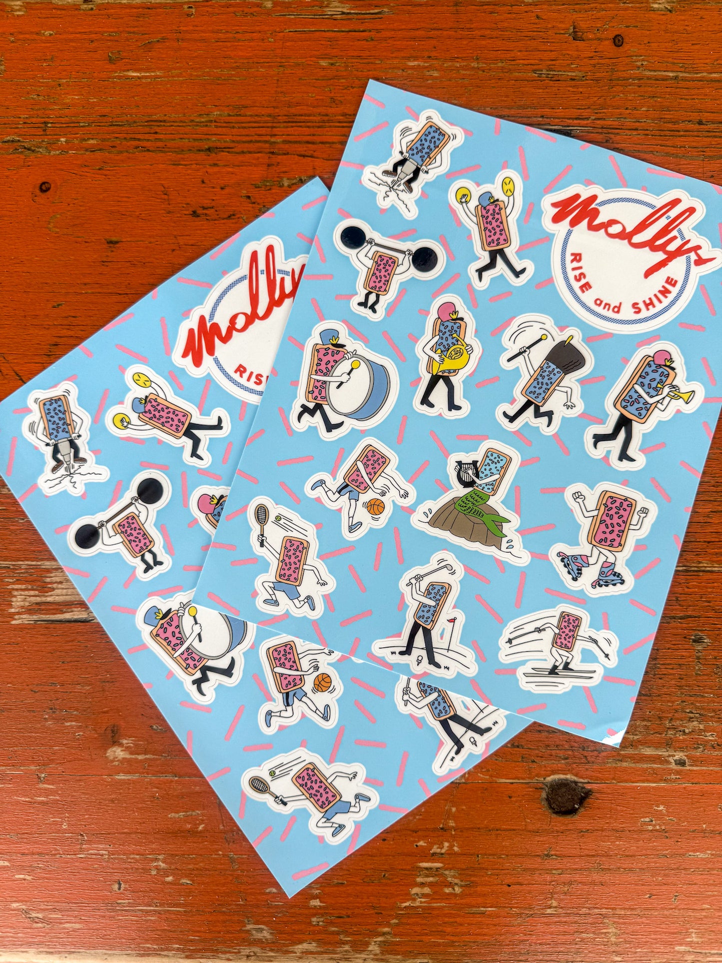 Two sheets of stickers with cartoon characters and 'Molly' branding on a wooden surface.