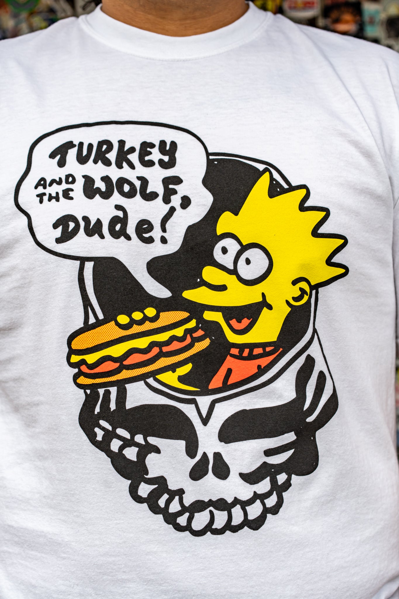 White t-shirt with a graphic design featuring a character, skull, and text 'Turkey and the Wolf Dude!'.
