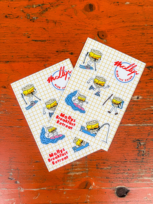 Two sheets of paper with cartoon biscuit character designs on a wooden surface