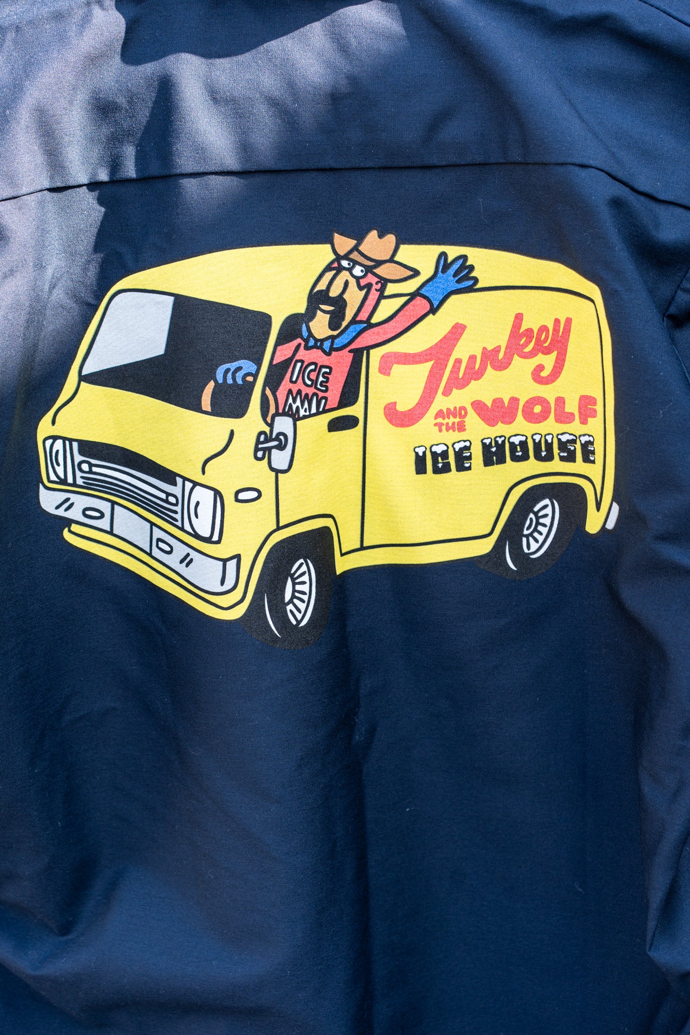 Blue jacket with a yellow van graphic and text on a blue background